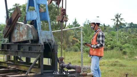 An Indonesian engineer checking oil derrick field. 4K Stock Footage 150772961