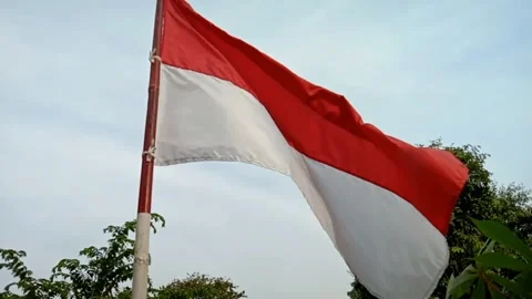 The Indonesian flag fluttering under a cloudy sky. Stock Footage 325612756