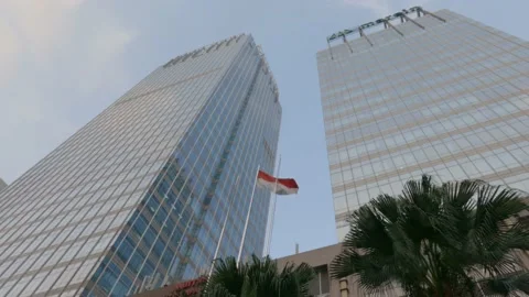The Indonesian flag fly flies between two skyscraper. Flat color profile, 4K. Stockbeeldmateriaal 153793010