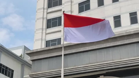 Indonesian Flag in Front of a Building Stock Footage 313724766
