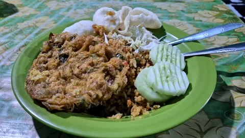 Indonesian fried rice with egg, cucumber, and crackers Stock Footage 343157745