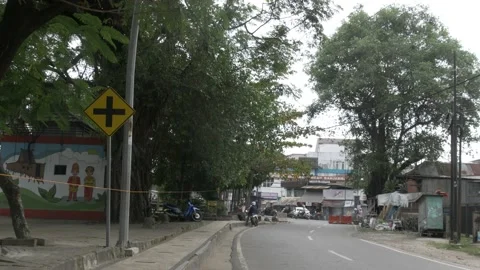 Indonesian intersection ahead warning traffic sign in the street of Banjarmasin Stock Footage 137435101