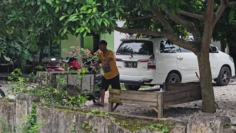 Indonesian Man Driving Motorcycle Garbage Cart On Village Street Video stock 345328740