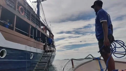 Indonesian Man Preparing to Dock a Small Boat Video stock 279874881