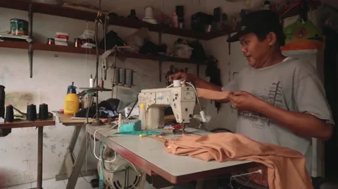 Indonesian man using sewing machine in a workshop, editorial Stock Footage 61022818