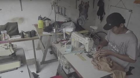 Indonesian man using sewing machine in a workshop, editorial, ungraded, slog2 Stock Footage 61023131