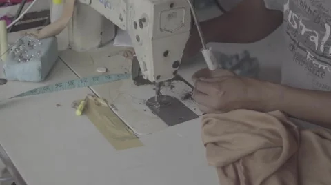 Indonesian man using sewing machine in a workshop, close up shot of hands 動画素材 61023386
