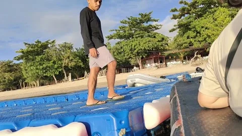 Indonesian Man Walking on Floating Platform at Beach Video stock 279874961