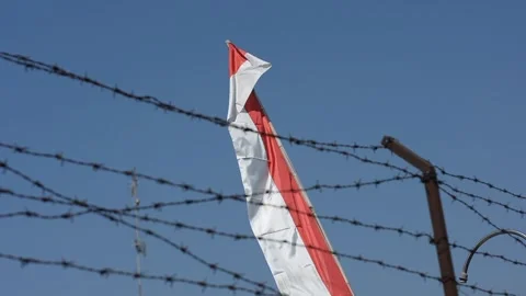 Indonesian Red and White Flag Waving Behind Barbed Wire Stock Footage 344880523