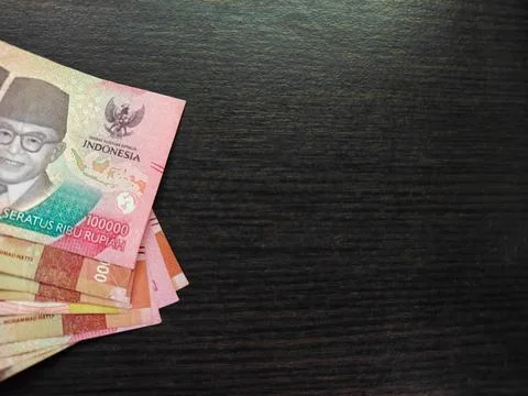Indonesian Rupiah Banknotes Stack on Dark Wooden Surface with Copy Space Foto stock