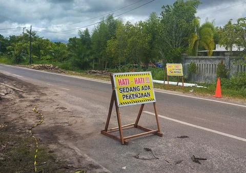 Indonesian 'Work in Progress' Warning Sign on the Roadside, Road Constructi.. Stock Photos