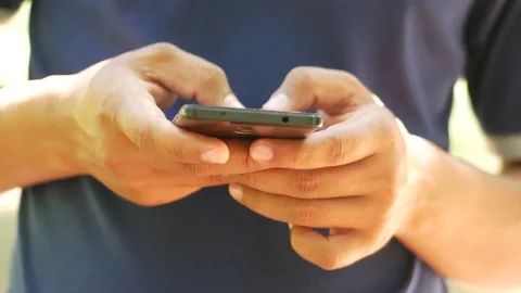 An Indonesian young man using apps on a touchscreen smartphone. 4K Stock Footage 139969635