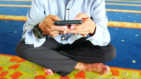 An Indonesian young man using apps on a touchscreen smartphone. Stock Footage 207331325