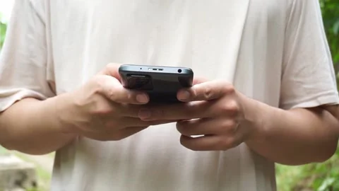 An Indonesian young man using smartphone Stock Footage 208298720