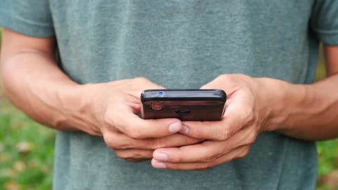 An Indonesian young man using a touchscreen smartphone typing a message Stock Footage 204636300