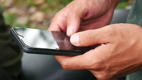 An Indonesian young man using a touchscreen smartphone typing a message Stock Footage 204707573