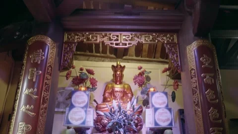An indoor altar of Temple featuring a central golden seated deity figure  Stock Footage 340626463