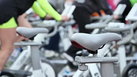 Indoor cycling class with people exercising on stationary bikes for fitness Stock Footage 335305579