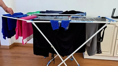 Indoor Laundry Drying Rack with Freshly Washed Clothes at Home Stock Footage 338317576