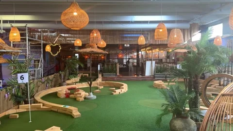 Indoor mini golf course with tropical themed obstacles. Stock Footage 341678264
