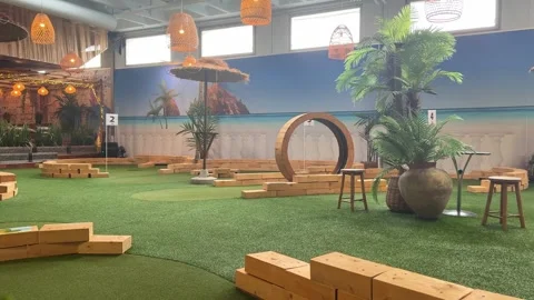 Indoor mini golf course with tropical themed obstacles. Stock Footage 341678296