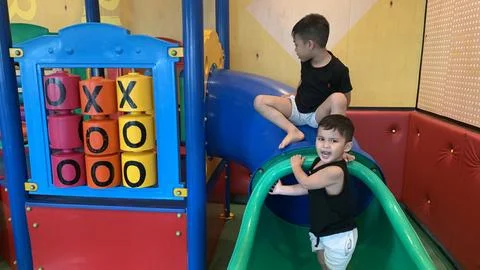 Indoor play structure featuring a slide and rotating tic-tac-toe panels Stock-Fotos