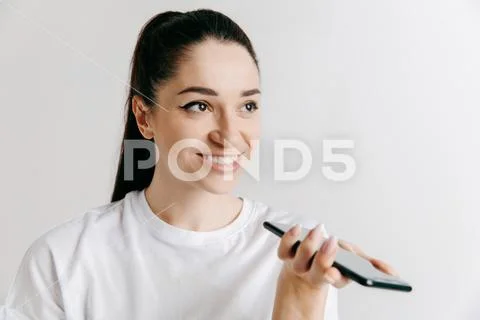 Indoor portrait of attractive young woman holding blank smartphone Stock Photos