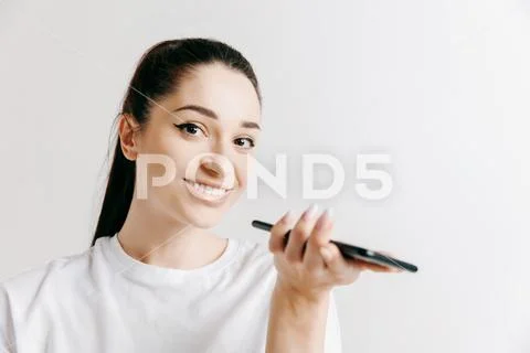 Indoor portrait of attractive young woman holding blank smartphone Stock Photos