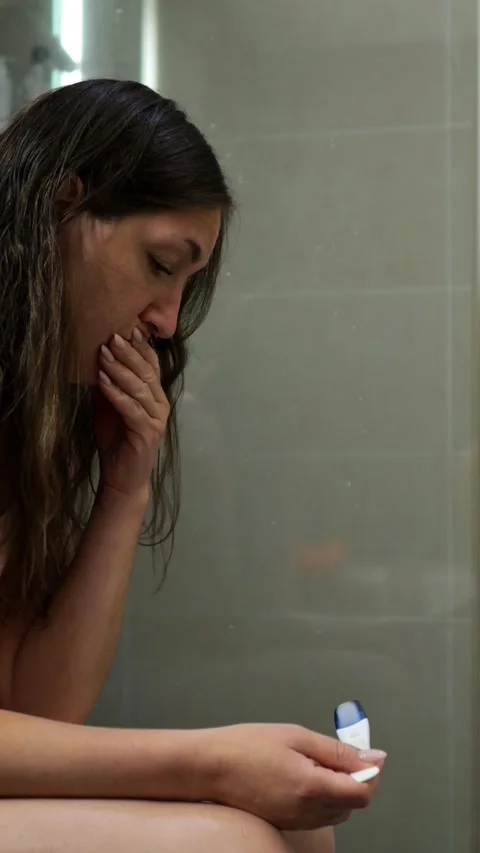 Indoor Scene Of Tense Pregnancy Test Reading. Woman Privately Reacts To Stock Footage 333441360
