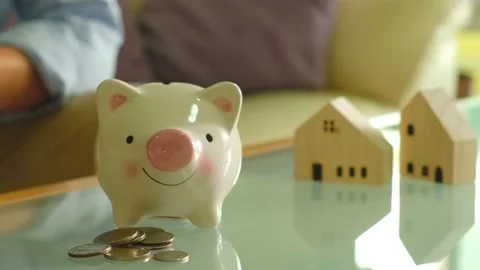 Indoor shot. Selective focus, close up at men hand put coins into piggy bank  Video stock 146363955