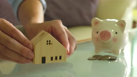 Indoor shot, selective focus at men hand put wooden house mock up beside blur Video stock 146363863