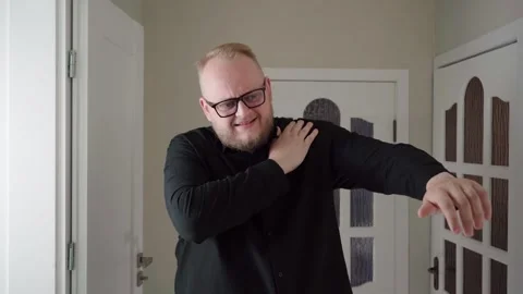 Indoor Shoulder Strain Concept as Man Raises Arm and Winces Stock Footage 342669865