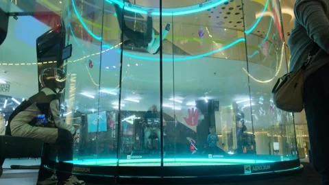Indoor skydiving instructor training participant in vertical wind tunnel at Vidéo 307782413