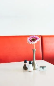 Indoor table setting in a cafe copy-space with flower in pot, salt and pepper Foto stock
