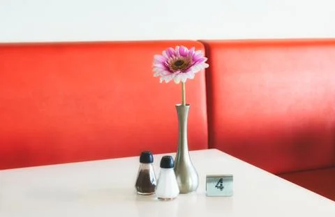Indoor table setting in a cafe with flower in pot, salt and pepper shakers an Stock Photos