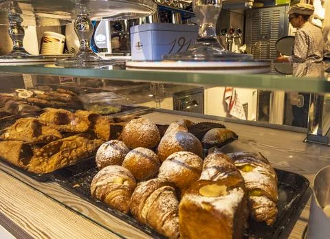 An indoor view of a bakery display case filled with fresh Italian pastries. Stock Photos
