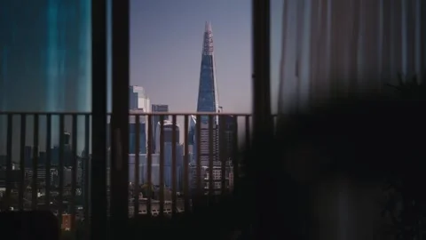 An indoor view looking out a glass door and balcony railing toward The Shard 스톡 동영상 346516598