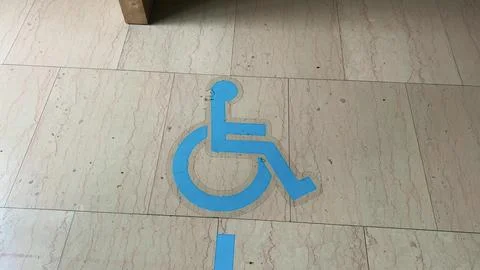 Indoor wayfinding color coded floor marking leading to the wheelchair icon 写真素材