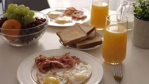 Indulge in a delightful breakfast featuring eggs and crispy bacon. Start your Video stock 276393915