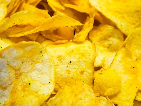 Indulgent Chips Stack. A stack of tempting potato chips with herbs. Stock Photos