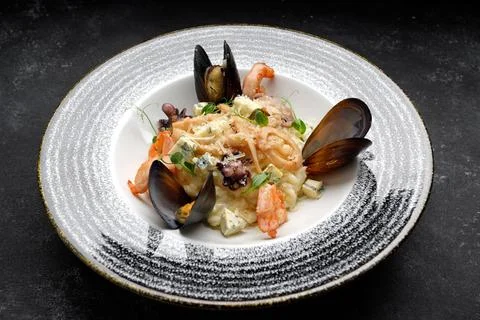 Indulgent seafood and cheese risotto with shellfish medley Stock Photos