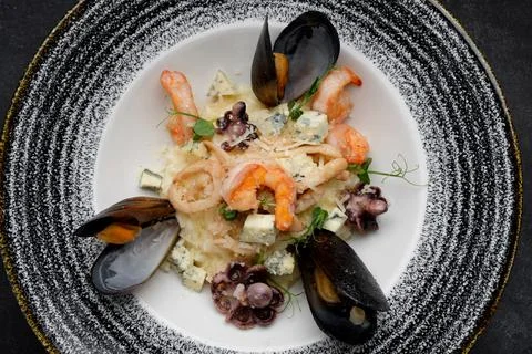 Indulgent seafood and cheese risotto with shellfish medley Stock Photos
