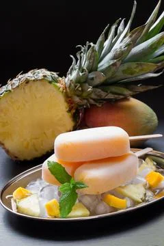Indulging in a refreshing mango pineapple ice cream dessert surrounded by fresh Stock Photos