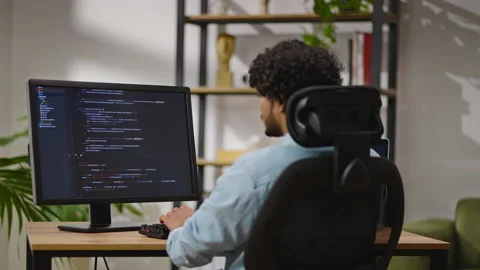 Indus man types source code on PC sitting in home office Stock Footage 239346593