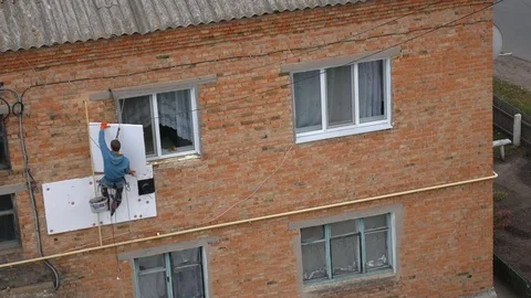Industrial alpinism. The work on the outer Insulate of an apartment house Stock Footage 81525466