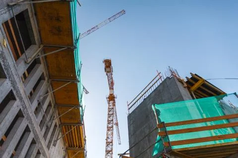 Industrial Background, bottom view of working crane on business building Fotos de archivo