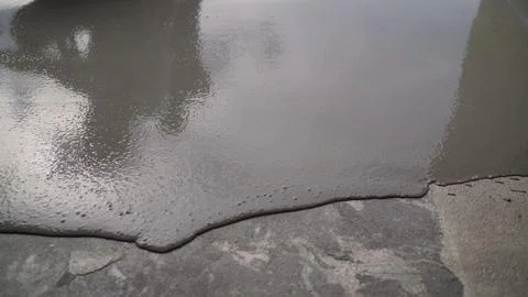 Industrial background showing process of applying liquid concrete mixture. Sm Stock Photos