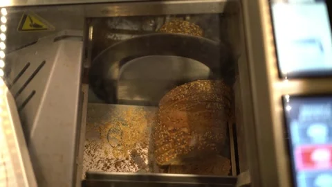 Industrial bread slicing machine cutting fresh loaf close up Stock Footage 343014553