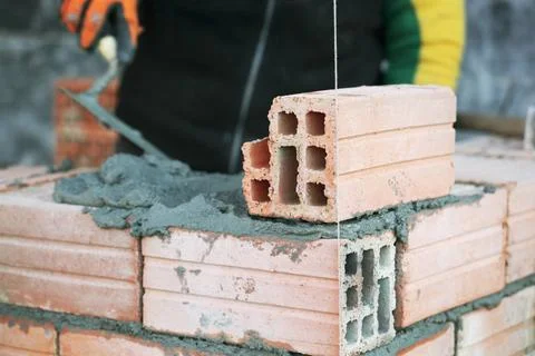 Industrial bricklayer installing bricks on construction site Industrial br... Stock Photos