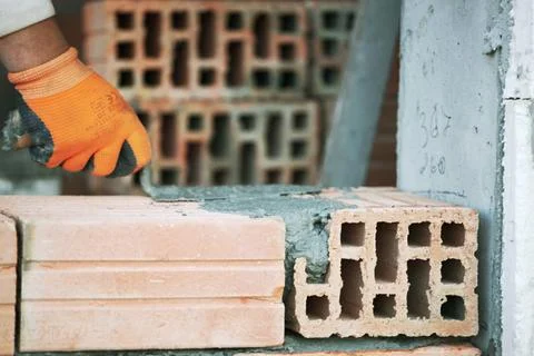 Industrial bricklayer installing bricks on construction site Industrial br... Stock Photos